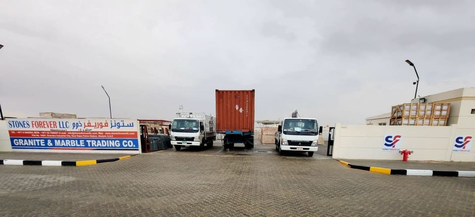 Delivery trucks beside the Stones Forever sign